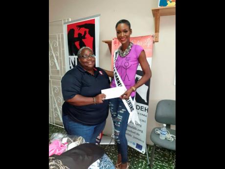 Miss Universe Jamaica finalist and sexual abuse survivor, Annecia Morgan, hands over a cash donation of $40,000 to executive director and co-founder of Eve for Life (EFL) Joy Crawford, at EFL offices in Kingston, recently.