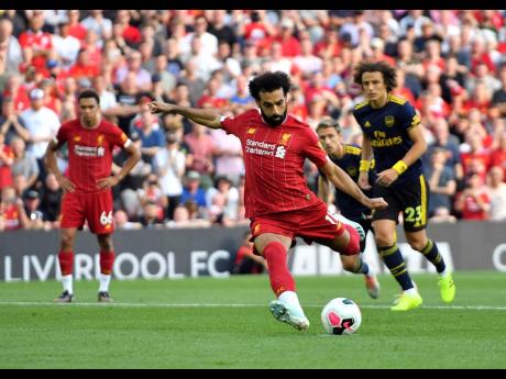
Liverpool’s Mohamed Salah scores his side’s second goal of the game from the penalty spot during their English Premier League match against Arsenal at Anfield, Liverpool, yesterday. 