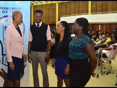 Fayval Williams, minister of science, energy and technology, speaks with (from right) Shantell Edwards, Shanieka Sans, and Danville Hamilton during the launch of the Technology Advancement Programme (TAP) at the Jamaica Conference Centre in downtown Kingston last Thursday. 