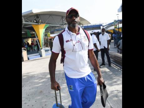 Interim West Indies coach Floyd Reifer arrives along with team members at the Norman Manley International Airport yesterday ahead of Friday’s start of the second Test against India at Sabina Park. 
