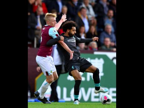 
Burnley’s Ben Mee (left) and Liverpool’s Mohamed Salah battle for the ball during the English Premier League match at Turf Moor, Burnley, England, yesterday. Liverpool won 3-0.