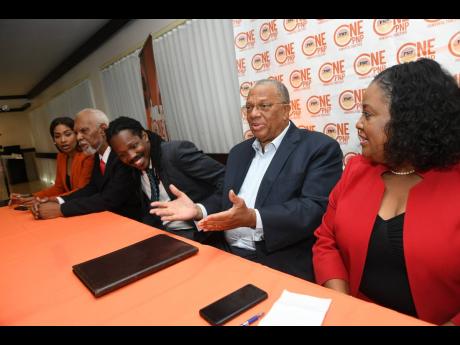 Dr Peter Phillips (second right), president of the People’s National Party, addresses members of the media during a press conference hosted by the OnePNP Campaign Team at The Jamaica Pegasus hotel in St Andrew yesterday.
