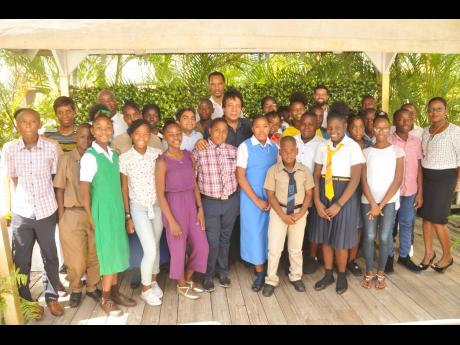 Guardsman Group Limited Executive Chairman Kenneth Benjamin (centre) along with staff members from Marksman Limited and Guardsman Limited congratulate the 2019 cohort of the Guardsman Foundation Primary Exit Profile Scholarship recipients during the awards ceremony on Thursday, August 29 at the Guardsman Group headquarters in St Andrew. 