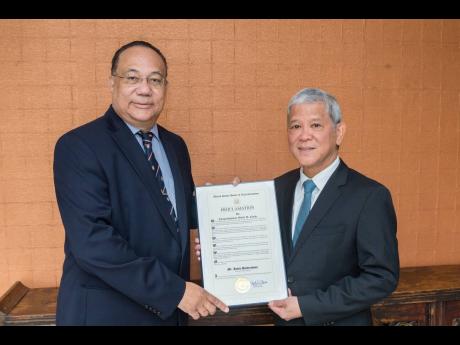 Ambassador Richard Bernal (left), pro-vice-chancellor, global affairs, The University of the West Indies, presents a proclamation of the United States House of Representatives to Kevin Hendrickson, chairman of the Courtleigh Group of Companies, at the Courtleigh Hotel on August 22.