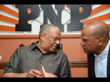Dr Peter Phillips (left) speaks with Peter Bunting at a PNP press conference on August 29, 2017.