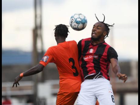 Tivoli Gardens’ Davion Garrison (left) goes up for a header with Arnett Gardens’ Vishinul Harris during the west Kingston derby in the Red Stripe Premier League at the Edward Seaga Sports Complex yesterday. 