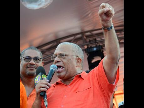 Dr Peter Phillips (right), president of the PNP, gives his victory speech at the National Arena after he defeated Peter Bunting in a leadership election. Looking on is Mikael Phillips, his son. Ian Allen/Photographer