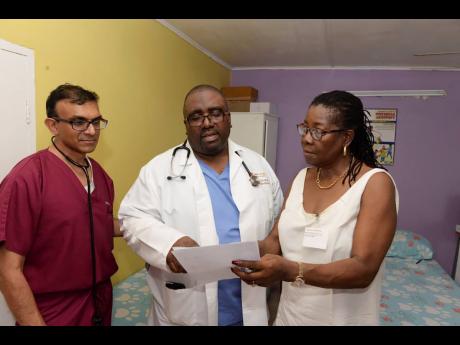 Help Jamaica Medical Mission president Dr Robert Clarke (centre) in discussion with leading cardiologist Dr Sunil Patel (left) and Norma Russell, chief liaison officer for the mission in Jamaica, during a screening of student athletes at St Jago High School, St Catherine, last Friday.