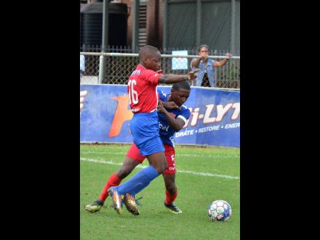 Justin Grant  of Holy Trinity (right) is challenged by Justin Patterson  of Clan Clarthy during yesterday’s ISSA/Digicel Manning Cup action at Winchester Park. The game ended 8-1 in favour of Holy Trinity.