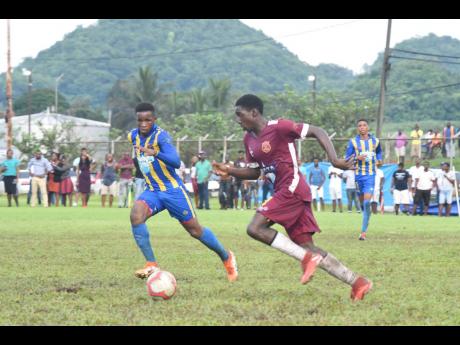 Mushtaq Christopher of STETHS (left) and Maggotty’s  Rohan Palmer in action in their ISSA/WATA daCosta Cup group E match at the Appleton Sports Complex yesterday. STETHS won 1-0. 