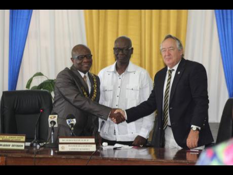 Burying the hatchet: Falmouth Mayor Collen Gager (left) and Trelawny Custos Paul Muschett shake hands as they pledged yesterday to work together for the better of the parish. Looking on is Local Government Minister Desmond McKenzie.