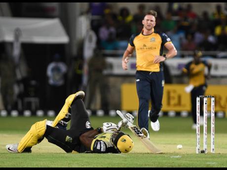 Jamaica Tallawahs batsman Andre Russell (on ground) is floored by a delivery by St Lucia Zouks pacer Hardus Viljoen (background) during their Caribbean Premier League game at Sabina Park in Kingston last night.