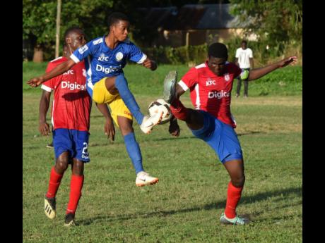 Hydel High School’s Delroy Trowers (centre) battles Campderdown High School’s goalscorer Jeovanni Laing (right) for possession, while Laing’s teammate, Cafu Washington, looks on during their ISSA/Digicel Manning Cup game in Caymanas Bay, St Catherine, yesterday.