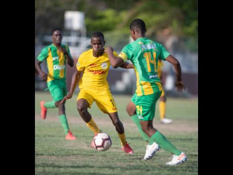 
Clive Beckford of Charlie Smith (left) goes on the attack against Vindiesel Isaacs of Kingston High School in their ISSA/Digicel Manning Cup fixture played at Breezy Castle yesterday. The game ended 1-1.