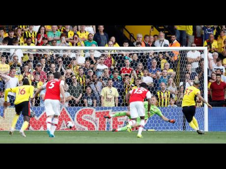 Watford’s Roberto Pereyra (right) scores his side’s second goal from the penalty spot during the English Premier League against Arsenal at the Vicarage Road stadium in Watford, near London, yesterday. 