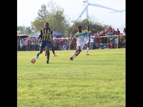 St Elizabeth Technical High School captain Antonio Biggs (right) tracks Munro College’s Torain Young during their ISSA/WATA daCosta Cup game at Munro on Saturday. 