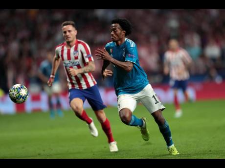 Atletico Madrid’s Saul (left) and Juventus’ Juan Cuadrado vie for the ball during the Champions League Group D match between Atletico Madrid and Juventus at the Wanda Metropolitano stadium in Madrid, Spain, yesterday. The match ended 2-2.