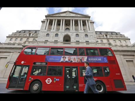 AP 
A London bus passes the Bank of England in London.