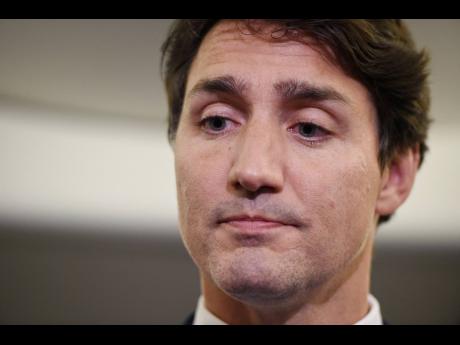 Canadian Prime Minister and Liberal Party leader Justin Trudeau reacts as he makes a statement in regard to a photo coming to light of himself from 2001 wearing ‘brownface,’ during a scrum on his campaign plane in Halifax, Nova Scotia, on Wednesday, September 18. 