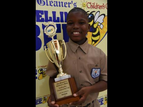 Jevede Rodney of Port Antonio Primary poses with the championship trophy after winning the Portland title yesterday.