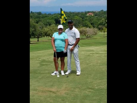 Garth Laird (right), senior national director, sales, Unique Vacations, and Mandy Litterini, travel agent, at the 10th hole during the opening day of the 17th Sandals US Travel Agents golf tournament at Sandals Golf and Country Club,  Upton, St Ann, yesterday.