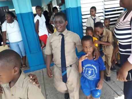 A ‘big brother’ escorting his ‘little brother’ to class at Free Town Primary School.