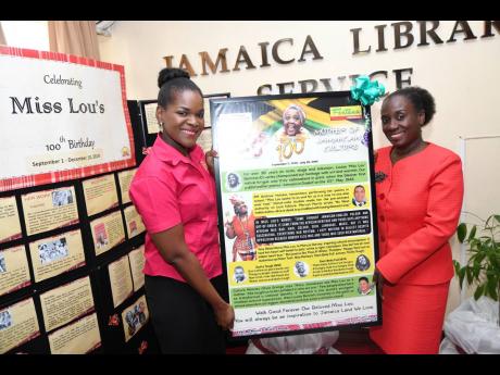 Stephanie Smith (left), special projects officer at Fontana Pharmacy, presents a Miss Lou storyboard to Maureen Thompson, director general of the Jamaica Library Service ((JSL), at a handover ceremony held at the JLS on Tuesday.