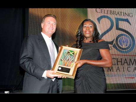 Barbara McDaniel receives the 2011 AMCHAM Jamaica Business and Civic Leadership Award for Arts and Culture (School or Community-Based Organisation) from Ron McKay.