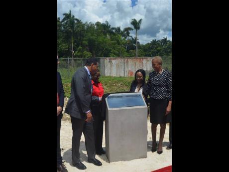Prime Minister Andrew Holness (left) participates in a plaque-unveiling ceremony at the Paradise Park Solar Farm in Savanna-la-Mar, Westmoreland, during an official inauguration ceremony for the facility on Wednesday. Also pictured, from second left: Cheryl Lewis, deputy director general of the Office of Utilities Regulation; Angella Rainford, director of Eight Rivers Energy Company Limited, which operates the facility; and Energy Minister Fayval Williams.