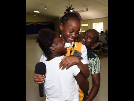 Toriann Beckford (centre) getting congratulatory hugs from her aunt, Letanya Grant (left), and grandmother, Winsome Hines, after winning the St Catherine parish championship in The Gleaner’s Children’s Own Spelling Bee 2019.