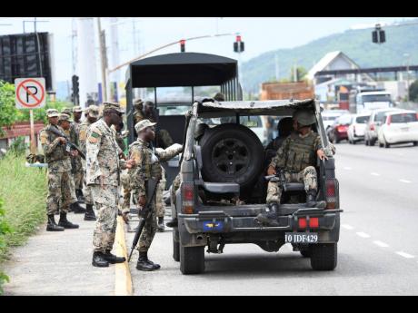 JDF soldiers setting up post on Washington Boulevard in the vicinity of Cooreville Gardens under the state of emergency in St Andrew South in late September.