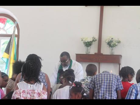 Reverend Shaun Nisbeth praying for the children recently at the St Stephen’s Anglican Church in Chantilly.