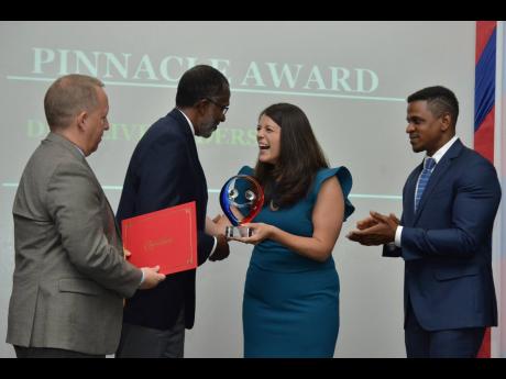 Dr Clive Anderson (second left)  specialist physician – dermatologist & HIV clinician in private practice, receives the Pinacle Award from Victoria Nibarger, PEPFAR coordinator, Caribbean Regional Programme. John McIntyre (left), chargé d’affaires at the US Embassy in Kingston and Jeremiah Knight, counsellor for public affairs at the embassy, look on. The occasion was the US Embassy’s SARA Awards ceremony held at the Spanish court Hotel on Friday, September 27.