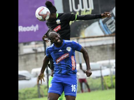 Mount Pleasant FA’s Francois Swaby (front) goes up for a header with Molynes United’s Andrew Peddlar in their Red Stripe Premier League encounter at the Drewsland Stadium yesterday.