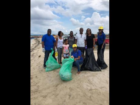 UNESCO youth ambassadors pose with Pearnel Charles Jr (second right) during a recent beach clean-up.