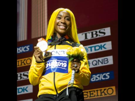 World 100 metres champion Shelly-Ann Fraser-Pryce with her gold medal after the presentation ceremony at the Khalifa International Stadium in Doha, Qatar.