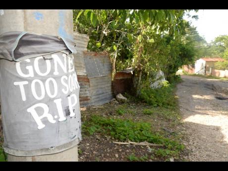 A shirt wrapped around a light post in the violence-pronce community of Farm in Clarendon in June in memory of a deceased resident of the area.