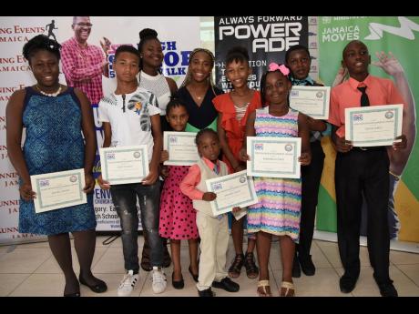 Multiple-times Olympic and World Champion Shelly-Ann Fraser-Pryce (centre) poses with the nine recipients of the Shelly-Ann Fraser-Pryce-Hugh Senior 5k Scholarship during an award ceremony at the Penwood Church of Christ in Waterhouse on Sunday.
