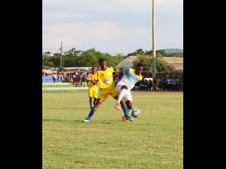 Sydney Pagon High School’s Christan White (left) and St Elizabeth Technical High School’s (STETHS) Rohan Brown (right) tussle for the ball during their ISSA/WATA daCosta Cup match at the STETHS Sports Complex on Wednesday, September 18, 2019.
