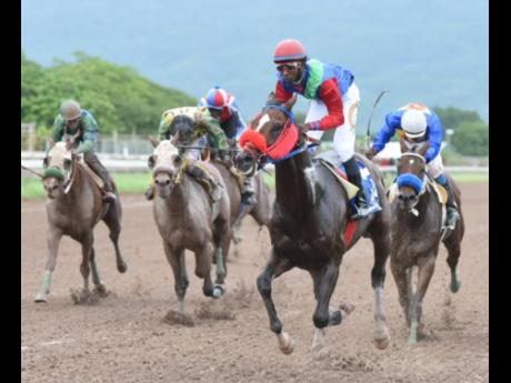 SUPERLUMINAL (second right), ridden by Omar Walker, finishes ahead of BRUCE WAYNE and DONTAE to take the Fontainbleu Trophy at Caymanas Park yesterday.