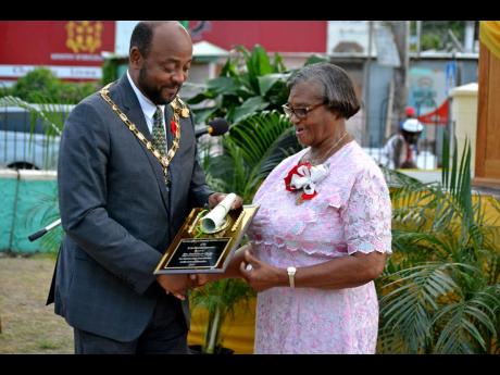 Buel Gloria Clarke collects her award from mayor of St Ann’s Bay Michael Belnavis. 
