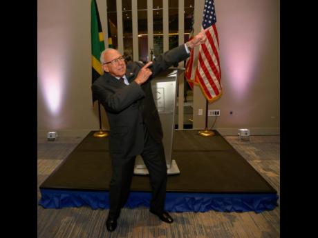 US ambassador to Jamaica, Donald Tapia. reprises Usain Bolt’s iconic pose at a reception held at the AC Marriott Hotel in Kingston on Wednesday. 