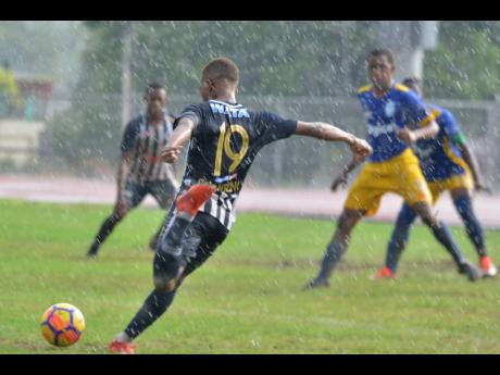 Jamaica College’s Rajae Lawrence takes a shot on goal during their ISSA/Digicel Manning Cup game against José Martí High School in heavy rainfall at the Ashenheim Stadium on Saturday, September 7, 2019.