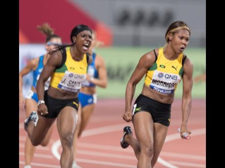 
Jamaica’s Jonielle Smith (left) urges on teammate Natasha Morrison, who powers her way through the anchor leg of their women’s 4x100m relay heat, at the IAAF World Championships at the Khalifa International Stadium in Doha, Qatar, on Friday, October 4.