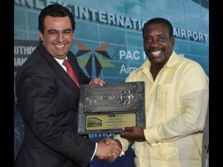 
Minister of Transport and Mining Robert Montague (right) presents the Keys to the City of Kingston to Chairman of PAC Kingston Airport Limited Raul Revuelta Musalem during the official ceremony to hand over the Norman Manley International Airport to PAC as the new concessionaire on Wednesday, October 16.