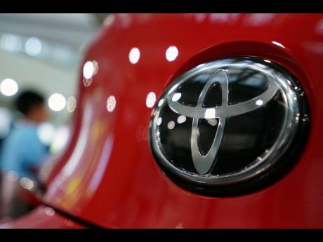 AP
In this August 2, 2019, file photo, people walk by the logo of Toyota at a showroom in Tokyo.