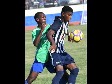 Jamaica College’s Alvarez Cooper (right) shields the ball from Vauxhall High School’s Sylvester Douglas during their ISSA/Digicel Manning Cup game at the Ashenheim Stadium on Friday, September 13, 2019.
