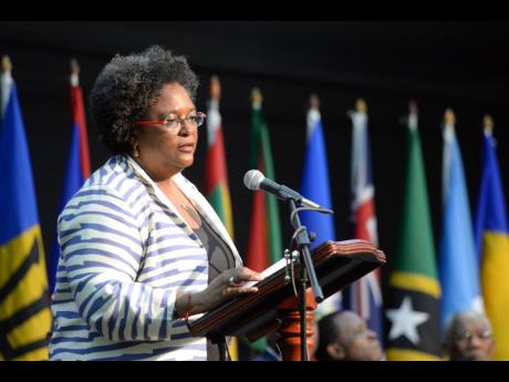 Flags of Caricom member states form a backdrop for Prime Minister of Barbados Mia Mottley as she addressed the 39th Caricom Heads of Government Meeting held in Montego Bay in July 2018. 