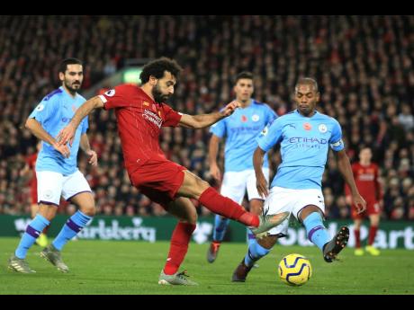 Liverpool’s Mohamed Salah (front) takes a shot on goal during their English Premier League match against Manchester City at Anfield Stadium in Liverpool, England, yesterday.