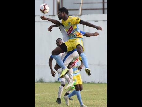 Waterhouse’s Colorado Murray (front) gets aerial in a physical challenge with Portmore United defenders during their Red Stripe Premier League clash at the Spanish Town Prison Oval yesterday.